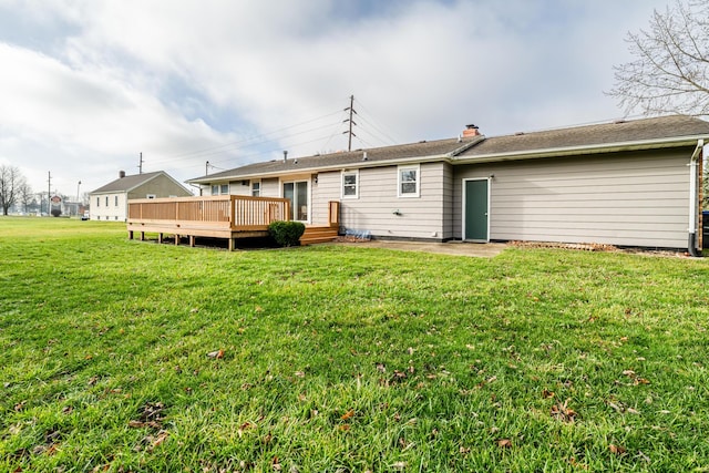 rear view of house featuring a deck and a lawn