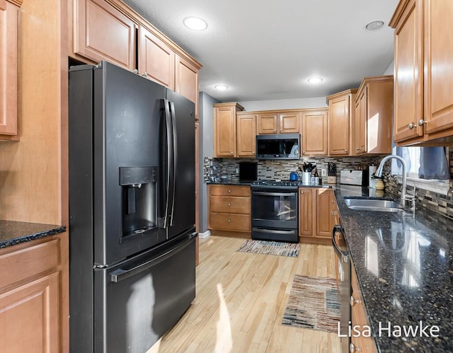 kitchen featuring sink, tasteful backsplash, dark stone counters, and black appliances