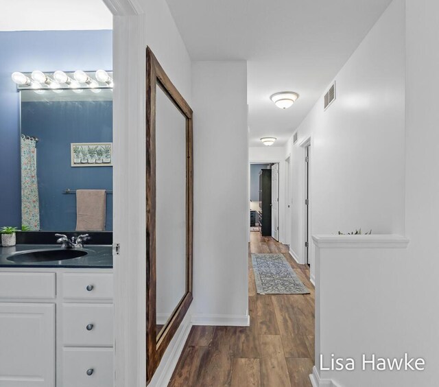 hallway featuring sink and dark wood-type flooring