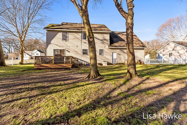 rear view of property with a lawn and a deck