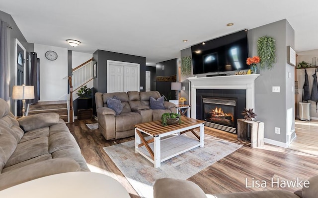 living room featuring hardwood / wood-style flooring and a tile fireplace