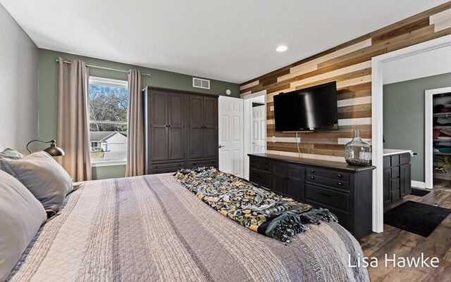 bedroom featuring dark hardwood / wood-style floors and wood walls