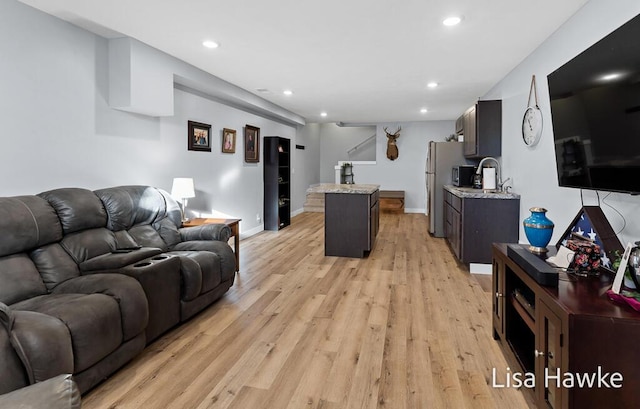 living room with light hardwood / wood-style flooring and sink