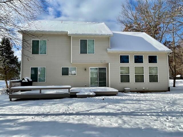 view of snow covered back of property