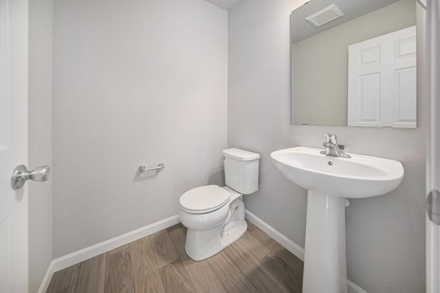 bathroom featuring sink, hardwood / wood-style floors, and toilet