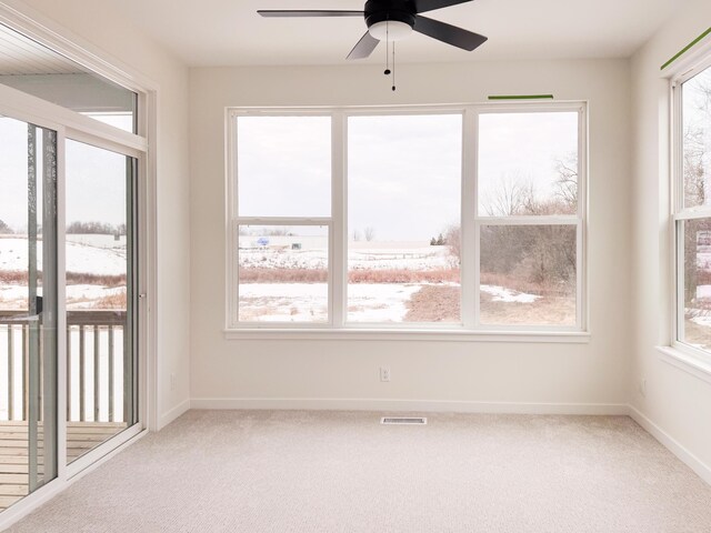 unfurnished sunroom with ceiling fan and a wealth of natural light