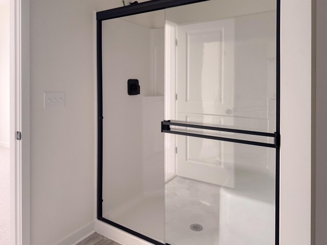 bathroom with a shower with door