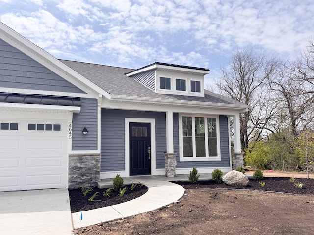 view of front of property with covered porch, a shingled roof, an attached garage, and stone siding