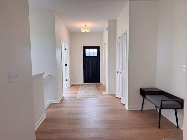 entrance foyer with baseboards and wood finished floors