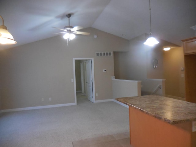 kitchen with ceiling fan, light colored carpet, hanging light fixtures, and vaulted ceiling