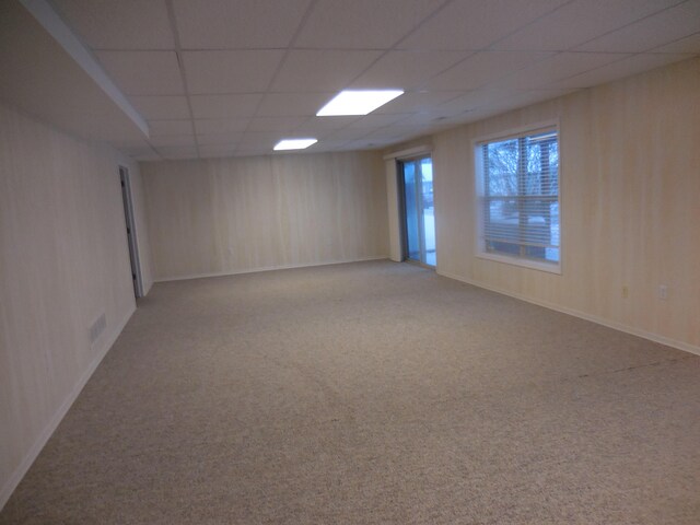 unfurnished room with a paneled ceiling and carpet floors