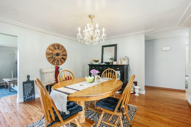 dining room with light hardwood / wood-style floors and an inviting chandelier