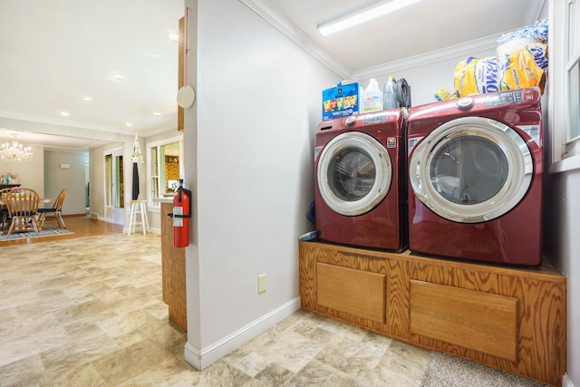 laundry room with washing machine and dryer, an inviting chandelier, and ornamental molding