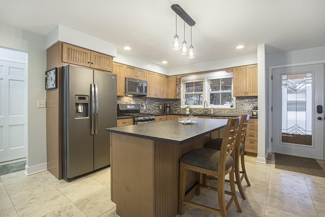 kitchen with decorative backsplash, stainless steel appliances, sink, decorative light fixtures, and a kitchen island