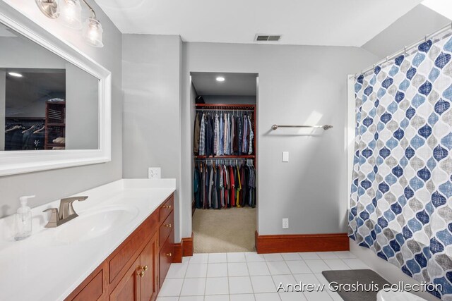 bathroom with tile patterned floors, vanity, and walk in shower