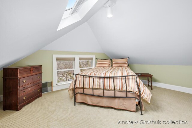 carpeted bedroom featuring lofted ceiling with skylight