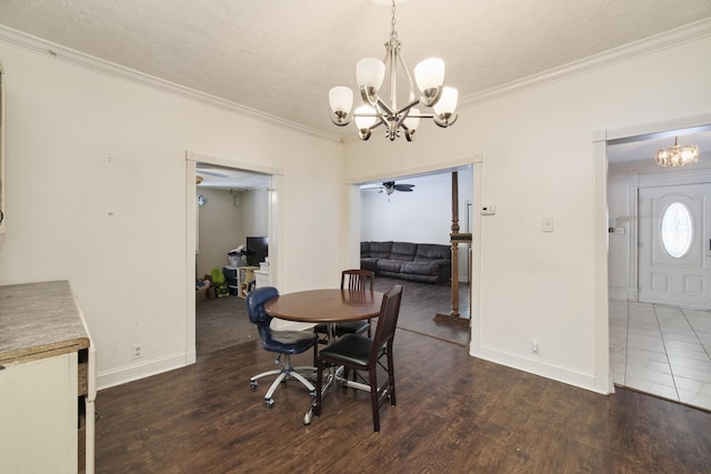 dining space with ceiling fan with notable chandelier, a textured ceiling, crown molding, and dark wood-type flooring