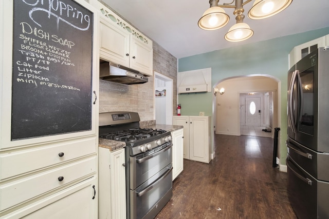 kitchen featuring stainless steel appliances, white cabinetry, dark stone countertops, and dark wood-type flooring