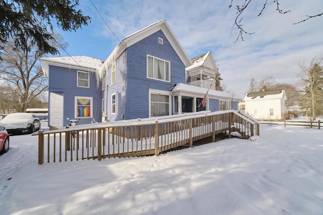 snow covered house with a deck