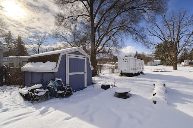 yard covered in snow with a storage shed