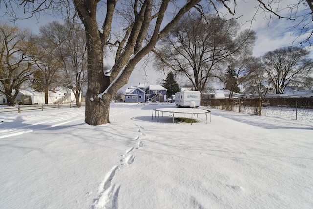 snowy yard featuring a trampoline