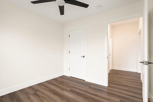 unfurnished bedroom featuring dark wood-type flooring, baseboards, and ceiling fan