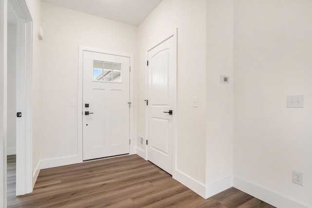 foyer featuring baseboards and wood finished floors