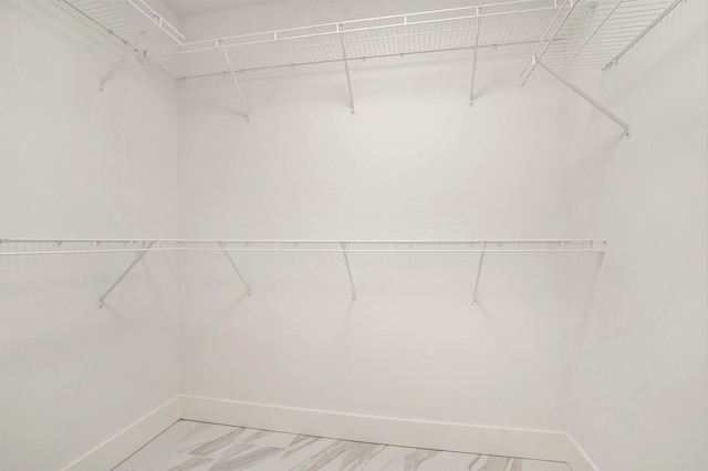 walk in closet with marble finish floor