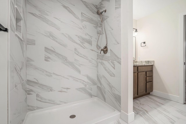 full bathroom with a shower stall, baseboards, marble finish floor, and vanity