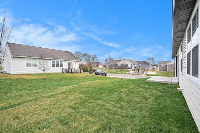 view of yard featuring fence, a residential view, and a patio