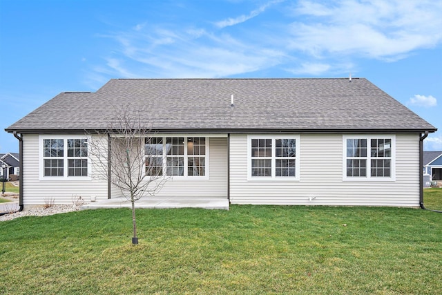 rear view of property with a shingled roof and a yard