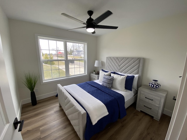 bedroom with baseboards, wood finished floors, and ceiling fan