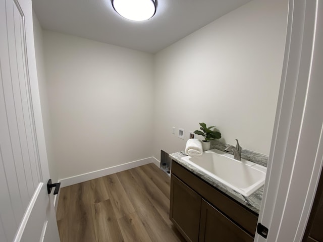 bathroom featuring baseboards, wood finished floors, and vanity