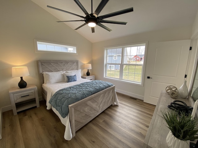 bedroom featuring lofted ceiling, baseboards, visible vents, a ceiling fan, and wood finished floors