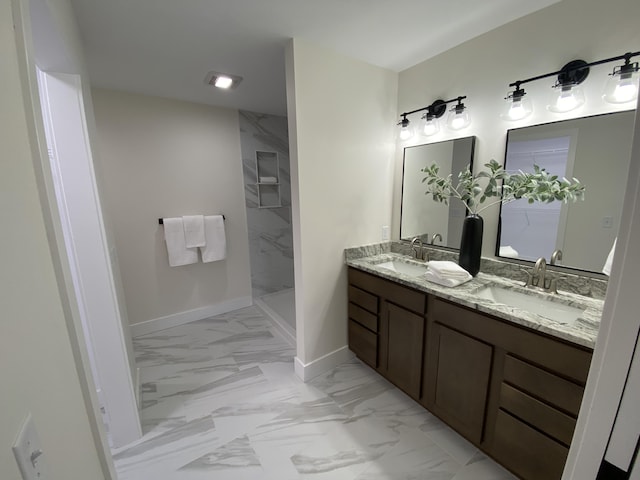 full bathroom featuring marble finish floor, baseboards, a walk in shower, and a sink