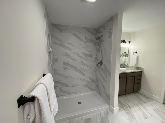 full bath featuring a stall shower, baseboards, marble finish floor, and vanity