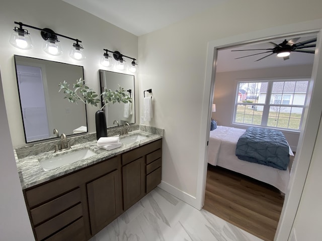 full bathroom featuring marble finish floor, baseboards, connected bathroom, and a sink