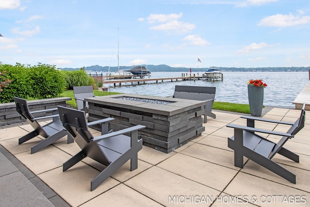 view of patio / terrace with a water view, a fire pit, and a boat dock