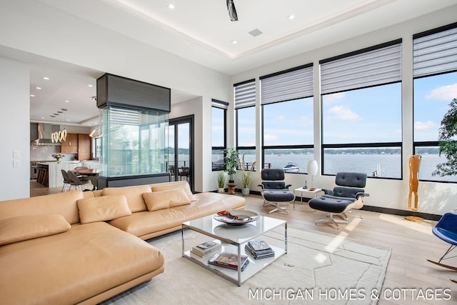 living room with a water view and light hardwood / wood-style floors