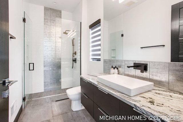 bathroom with vanity, toilet, tile walls, and walk in shower