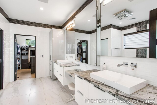 bathroom featuring vanity and tile walls