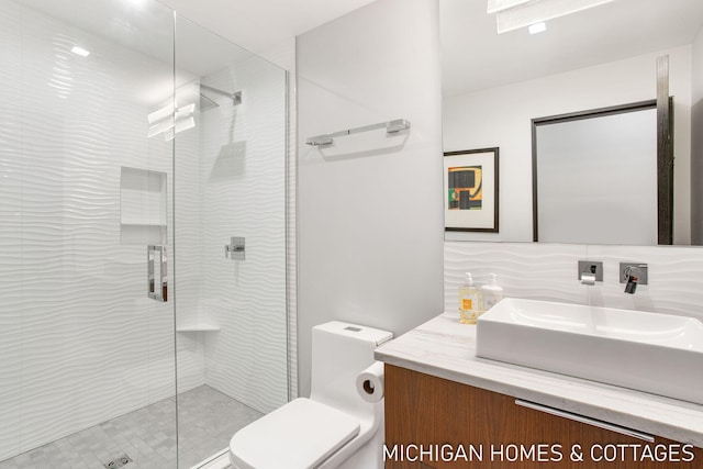 bathroom with vanity, backsplash, toilet, and a shower with shower door