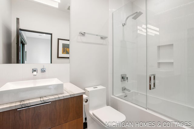 full bathroom featuring toilet, vanity, and combined bath / shower with glass door