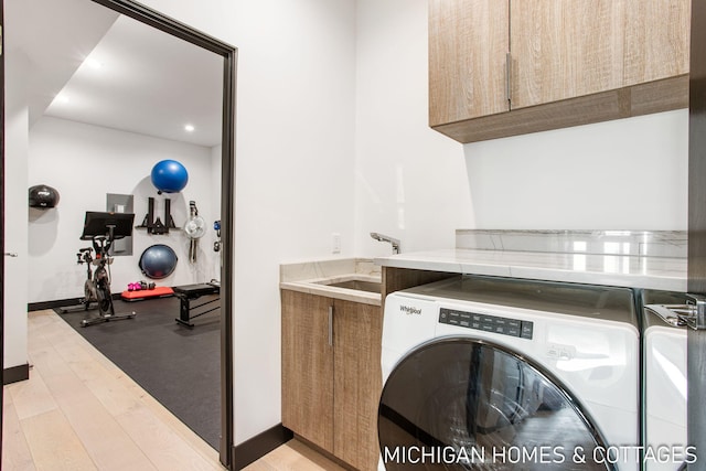 washroom featuring sink, cabinets, and light wood-type flooring