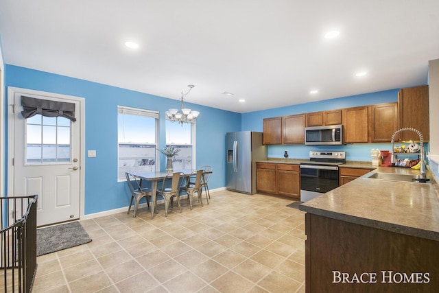 kitchen featuring pendant lighting, a notable chandelier, sink, and stainless steel appliances