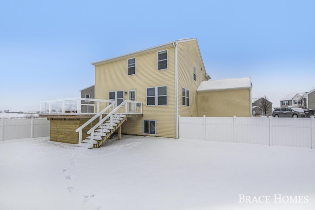 snow covered rear of property featuring a wooden deck