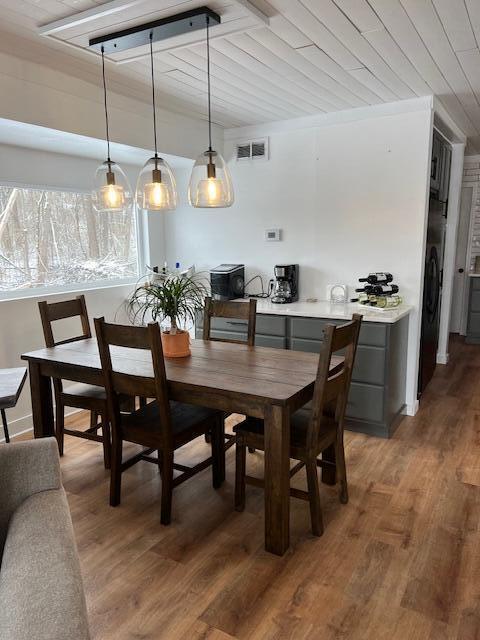 dining room with dark hardwood / wood-style floors and wood ceiling