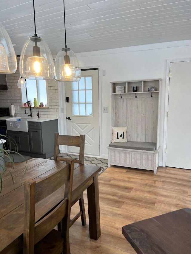 dining space with wooden ceiling, sink, and light hardwood / wood-style flooring