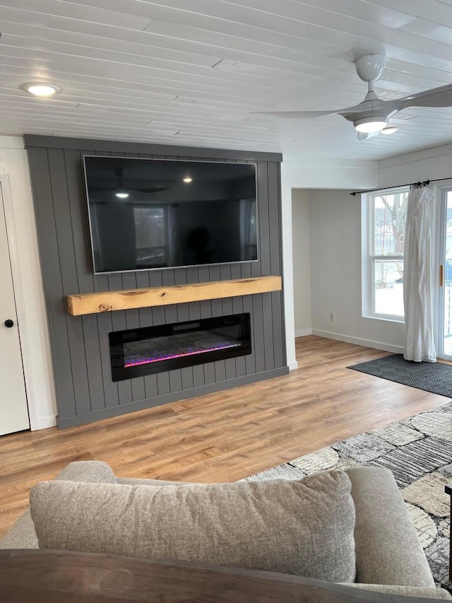 living room with a fireplace, wood ceiling, and light wood-type flooring