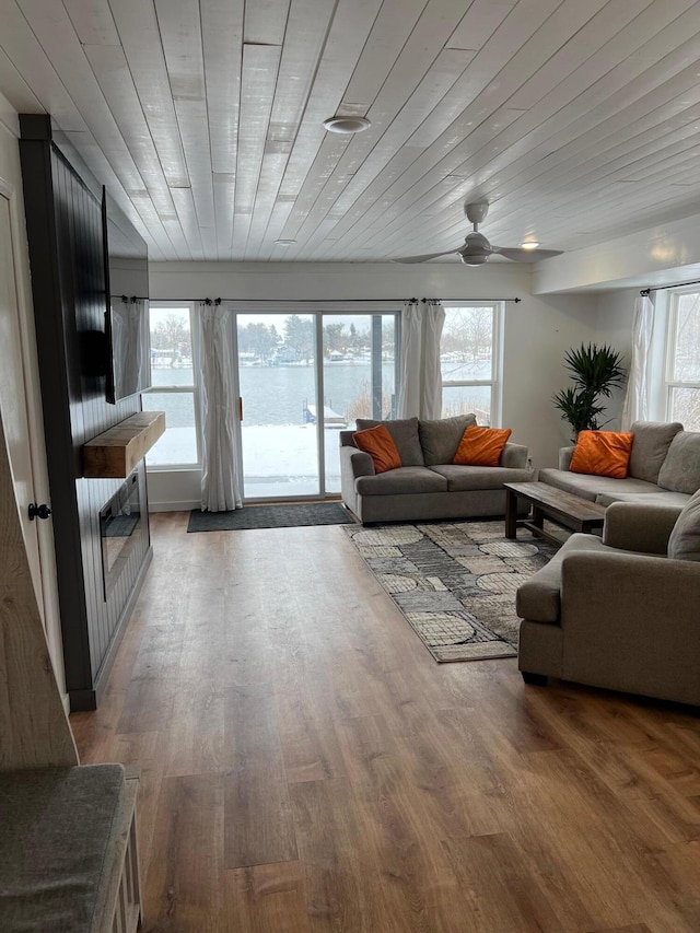 living room featuring ceiling fan, wood-type flooring, and wooden ceiling